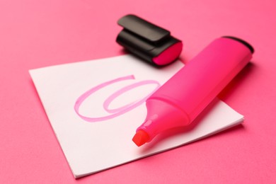 Photo of Bright color marker and sticky note on pink background, closeup