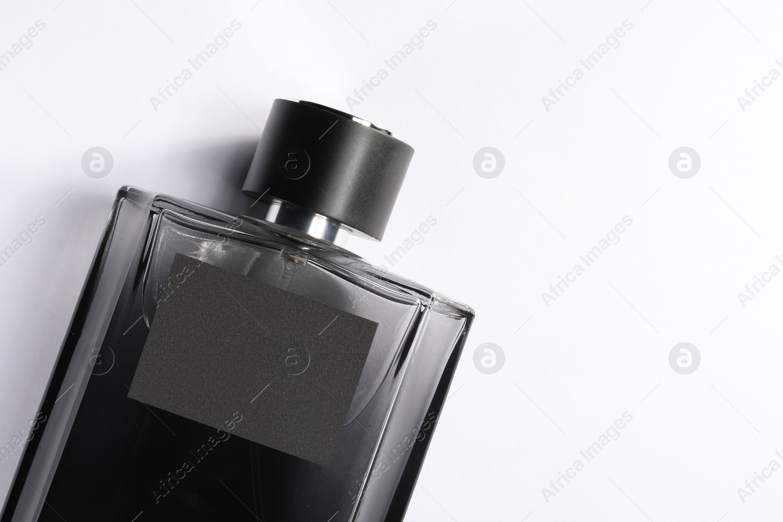 Photo of Luxury men`s perfume in bottle on white background, top view. Space for text