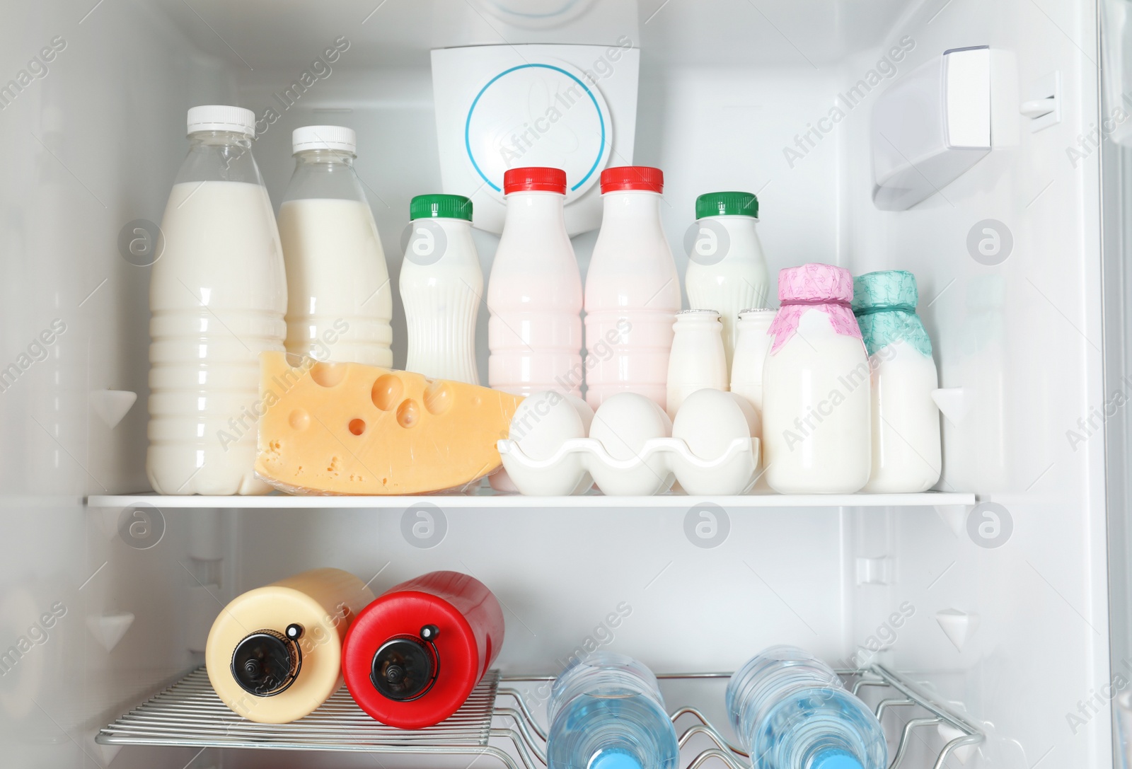 Photo of Open refrigerator with many different products, closeup