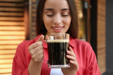 Photo of Beautiful woman with cold kvass outdoors. Traditional Russian summer drink