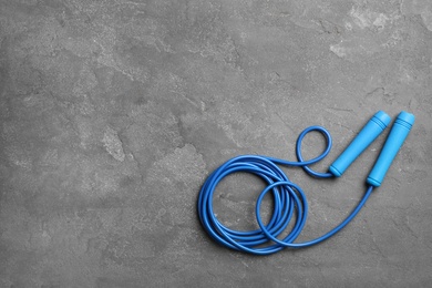 Photo of Jump rope and space for text on grey background, top view