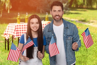 Image of 4th of July - Independence day of America. Happy father and daughter with national flags of United States having picnic in park