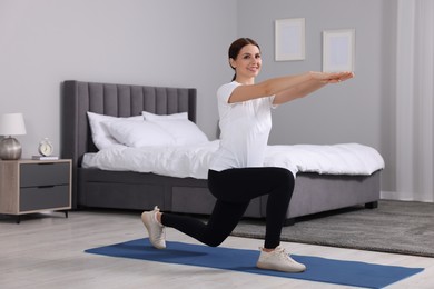 Happy woman doing morning exercise at home, space for text