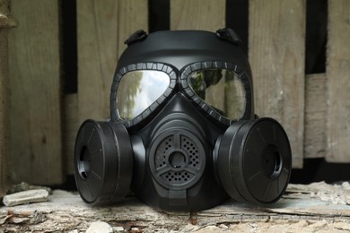Photo of One gas mask on stone surface outdoors. Safety equipment