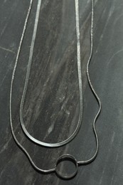 Metal chains on grey table, flat lay. Luxury jewelry