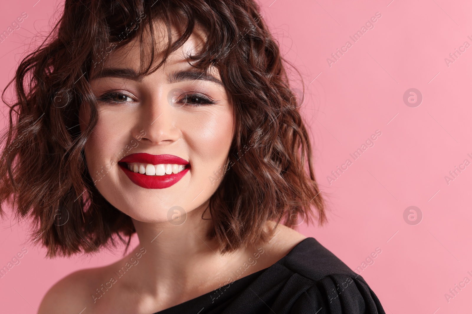 Photo of Beautiful young woman with wavy hairstyle on pink background. Space for text
