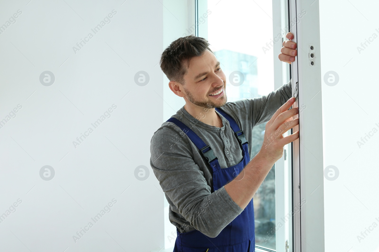 Photo of Construction worker installing plastic window in house