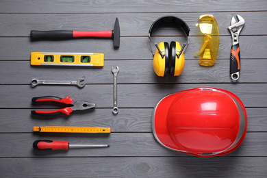 Flat lay composition with different construction tools on grey wooden background