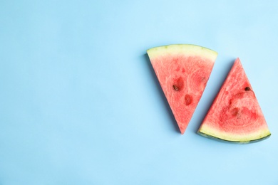 Photo of Slices of ripe watermelon on light blue background, flat lay. Space for text