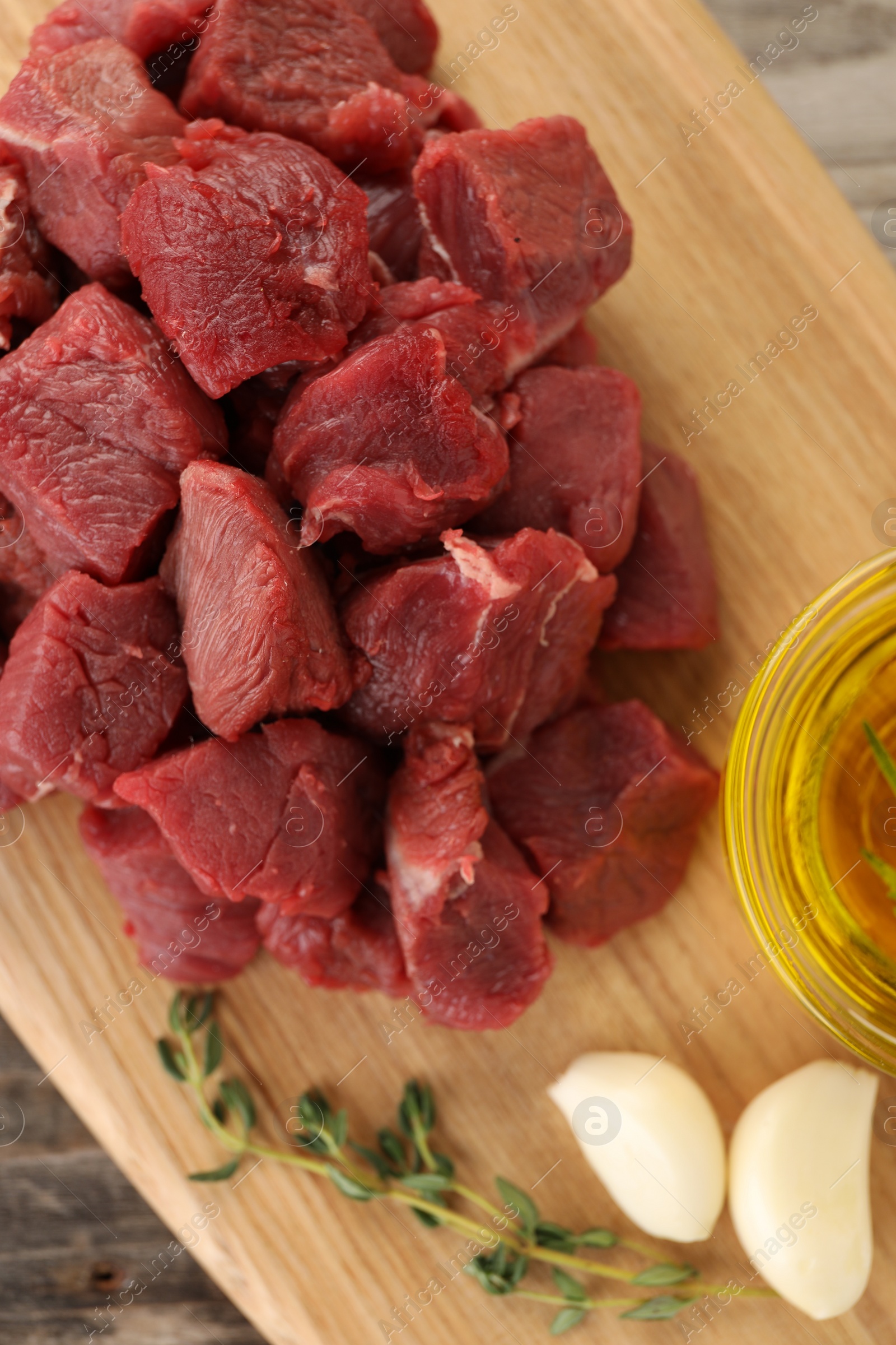 Photo of Pieces of raw beef meat and garlic on table, top view