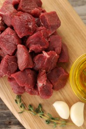 Photo of Pieces of raw beef meat and garlic on table, top view