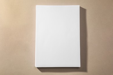 Photo of Stack of blank paper sheets on light brown background, top view. Space for text