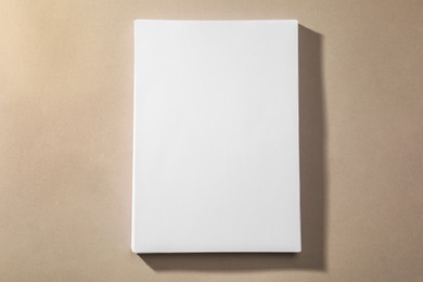 Stack of blank paper sheets on light brown background, top view. Space for text