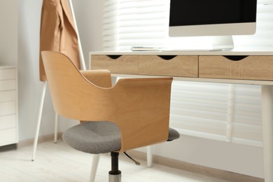 Photo of Stylish office chair at workplace in room. Interior design