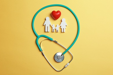 Photo of Flat lay composition with heart, stethoscope and family figure on color background. Life insurance concept