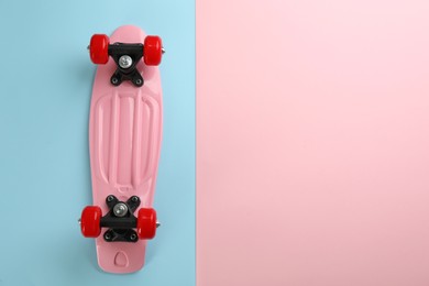 Pink skateboard on color background, top view. Space for text