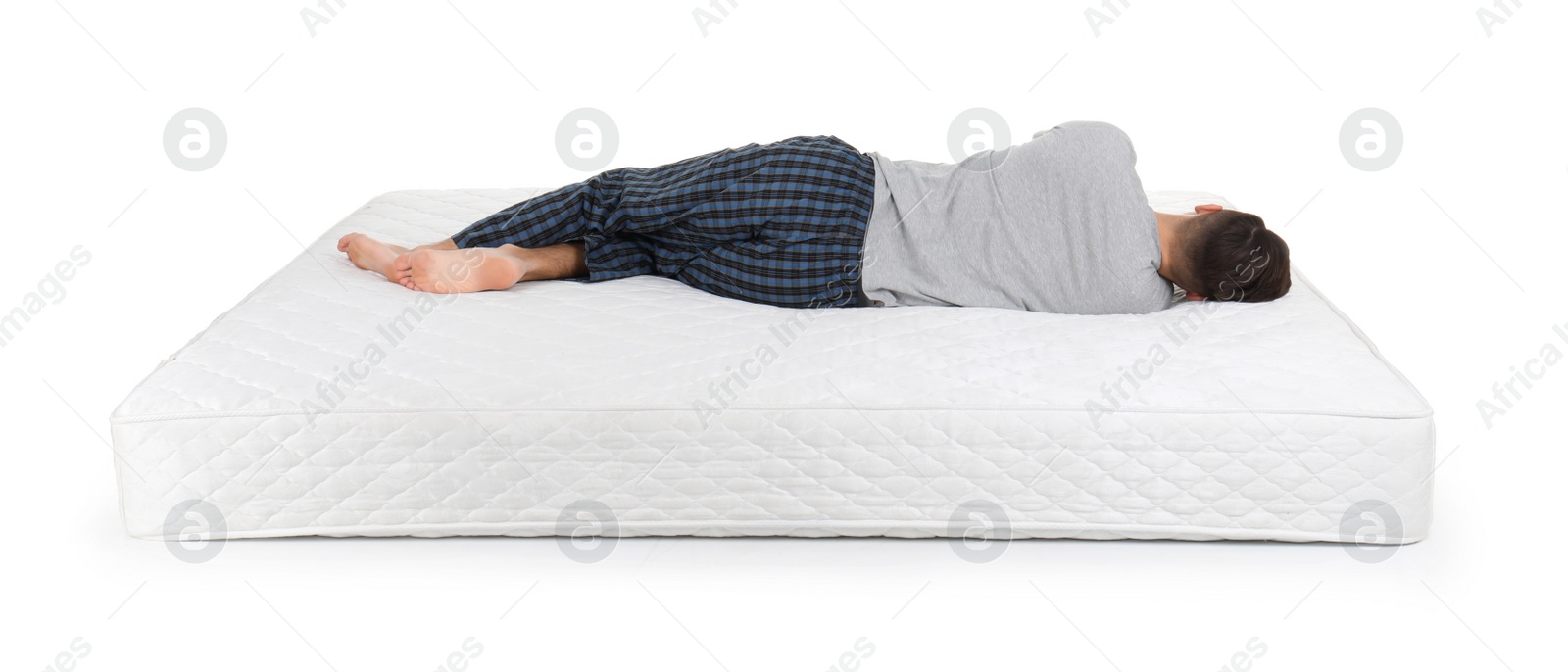 Photo of Young man lying on mattress against white background