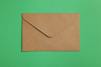 Envelope made of parchment paper on green background, top view