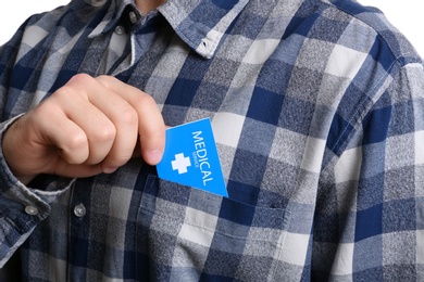 Photo of Man putting business card into pocket, closeup. Medical service