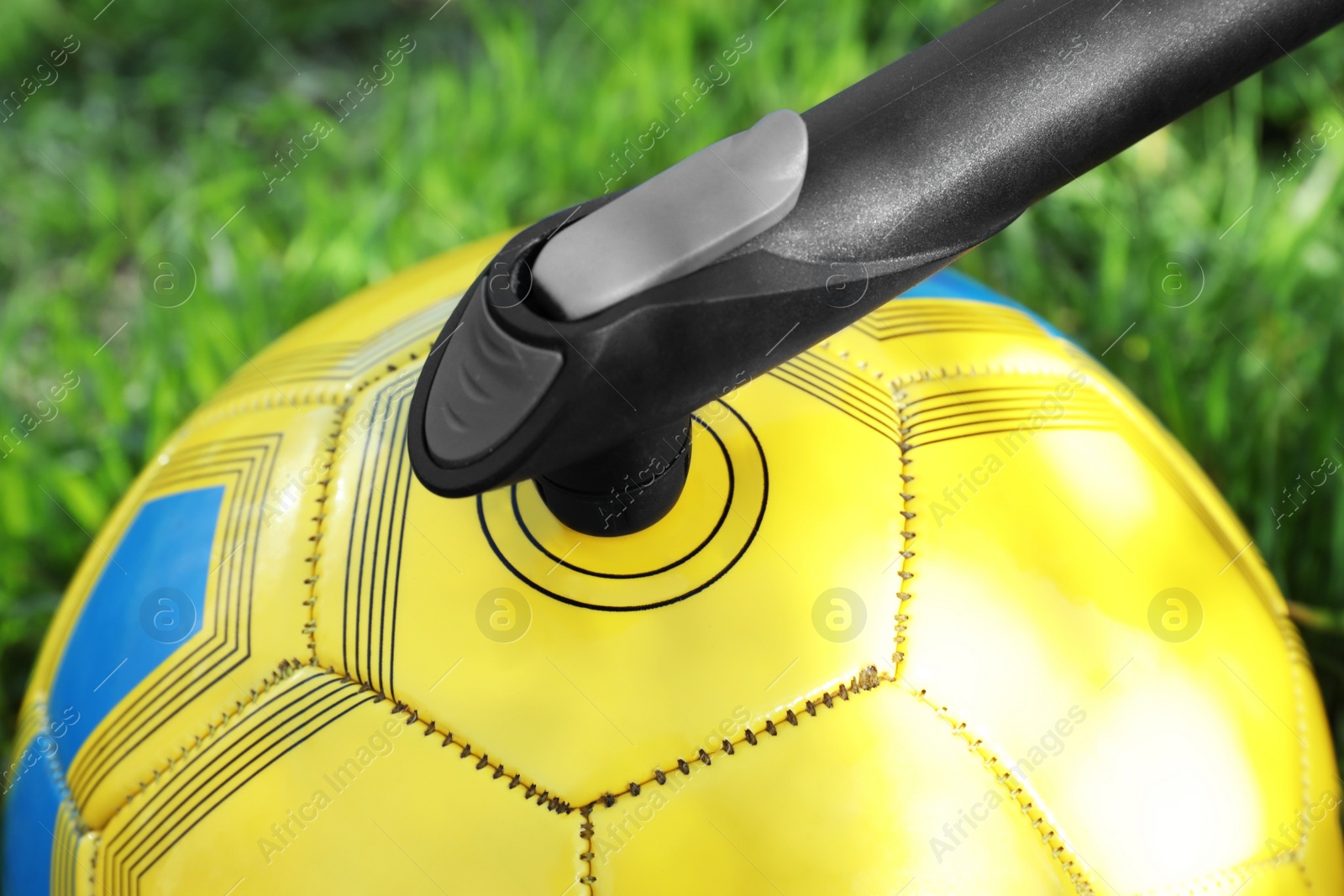 Photo of Inflating ball with manual pump outdoors, closeup