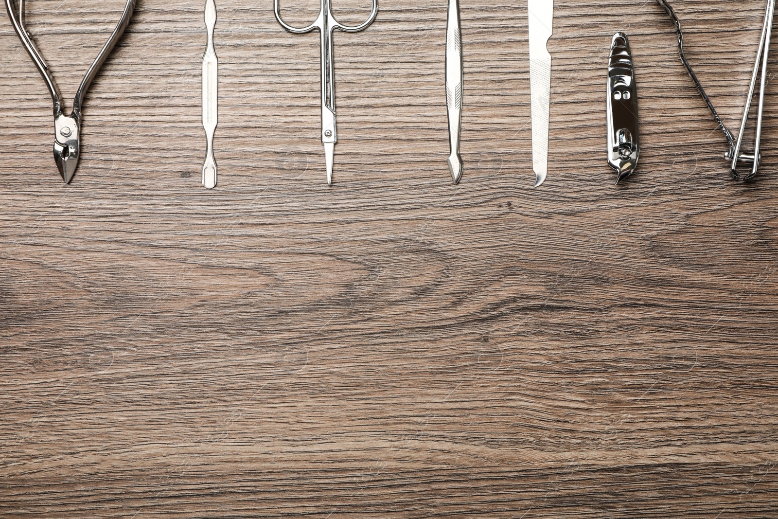 Photo of Set of manicure tools on wooden table, flat lay. Space for text