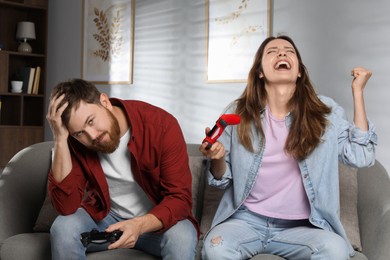 Couple playing video game with controllers at home