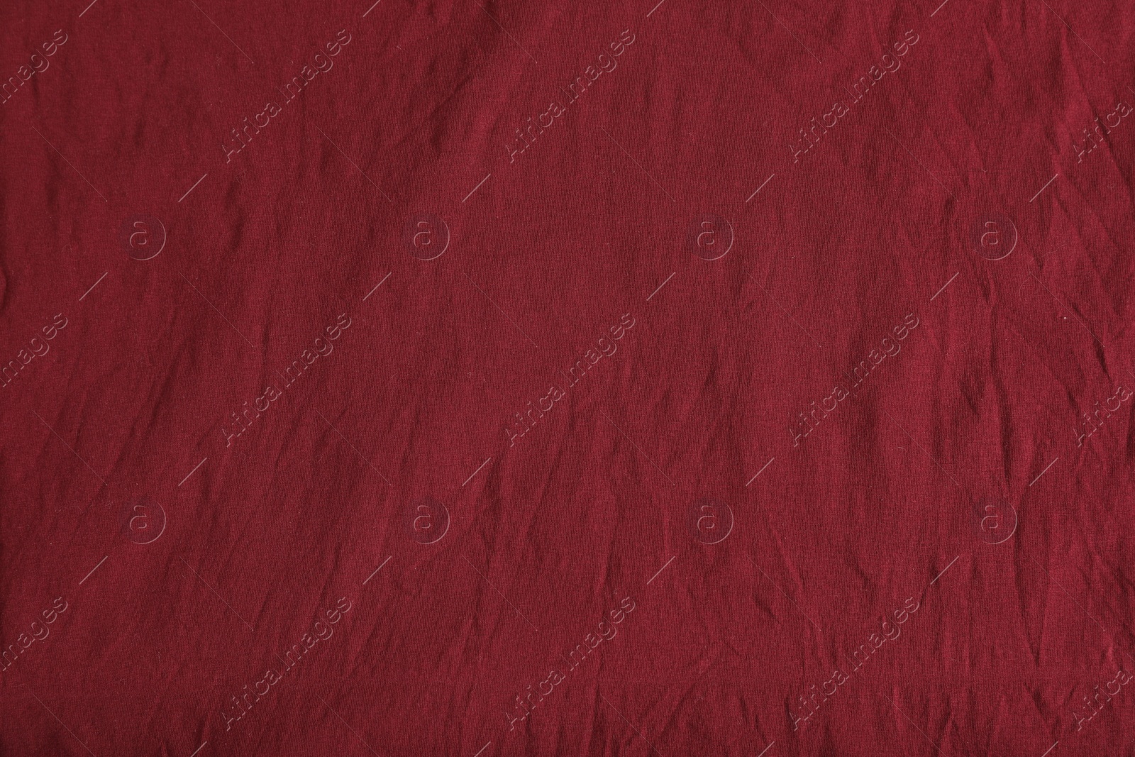 Photo of Crumpled dark red fabric as background, top view