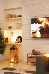 Photo of Plasma TV on white wooden wall in living room beautifully decorated for Christmas