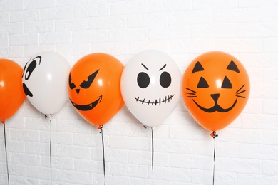 Color balloons for Halloween party against white brick wall