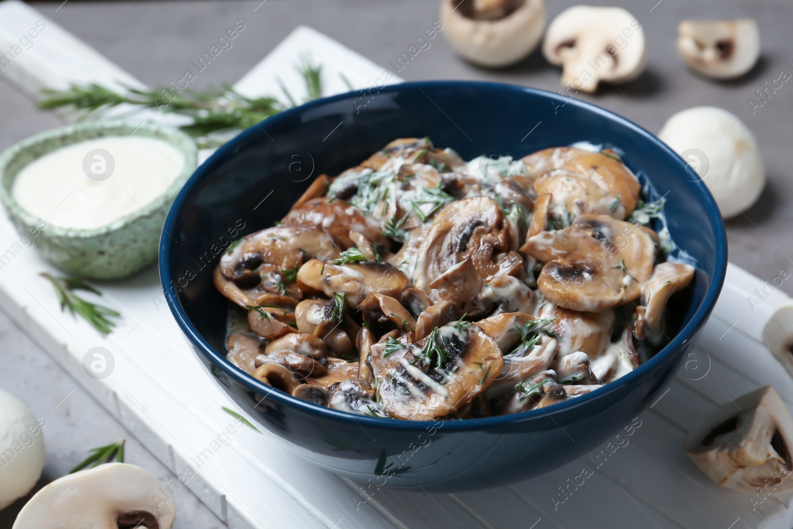 Photo of Bowl of fried mushrooms with sauce on table