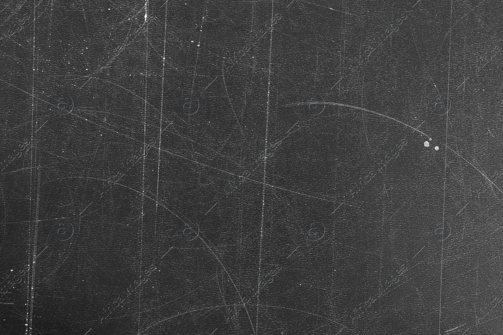 Photo of Texture of scratched black surface as background, closeup