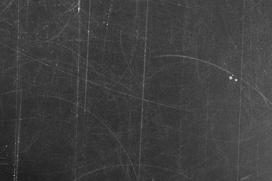 Photo of Texture of scratched black surface as background, closeup