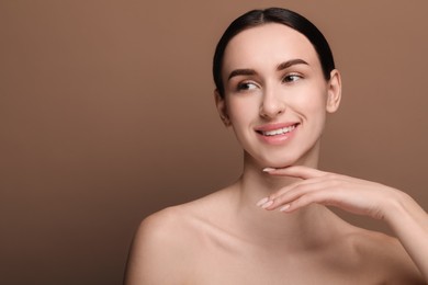 Portrait of beautiful young woman on brown background. Space for text