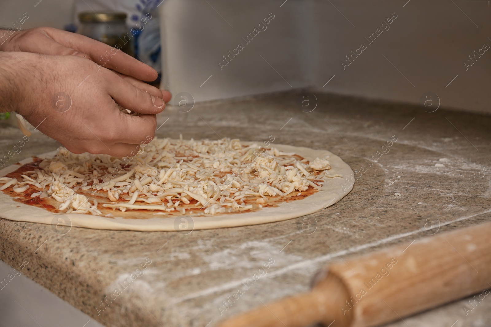 Photo of Man preparing pizza at table, closeup. Oven recipe