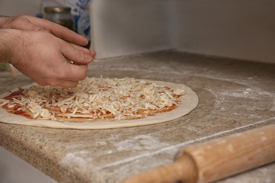 Man preparing pizza at table, closeup. Oven recipe