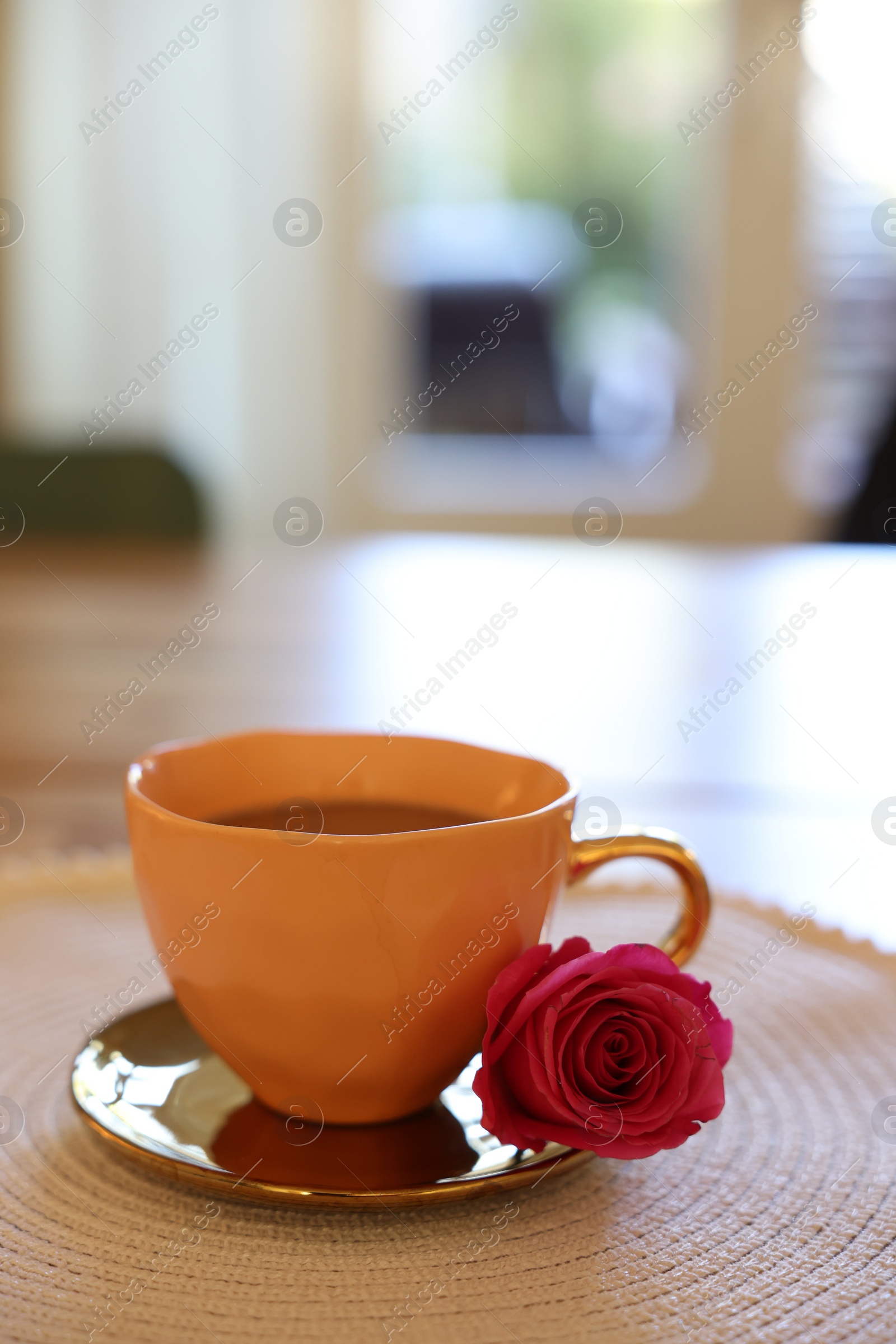 Cup of hot drink and red rose on table indoors. Space for text Photo of Cup of hot drink and red rose on table indoors. Space for text
