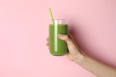 Photo of Woman holding glass of tasty smoothie against pink background, closeup