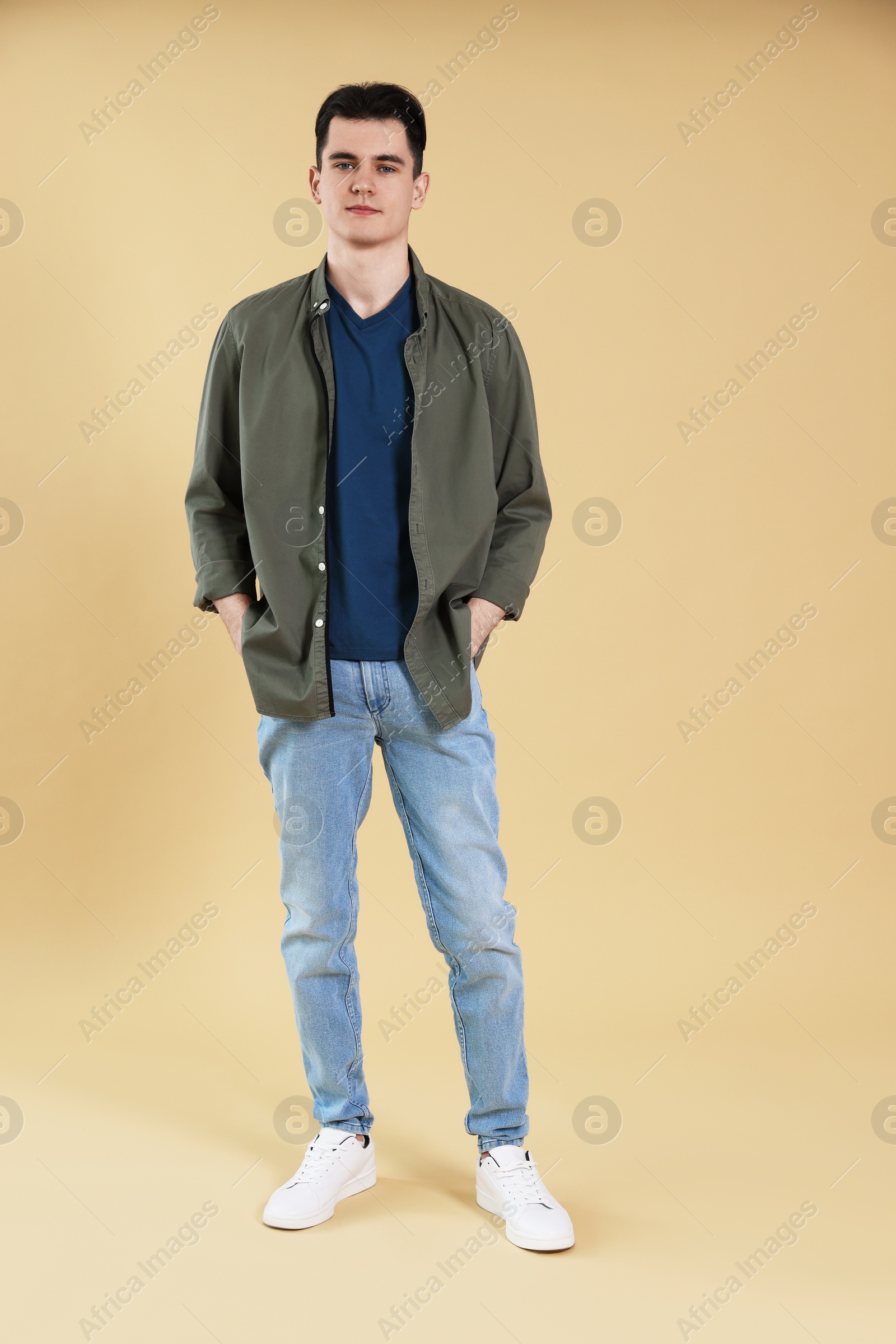 Photo of Full length portrait of handsome young man in on beige background