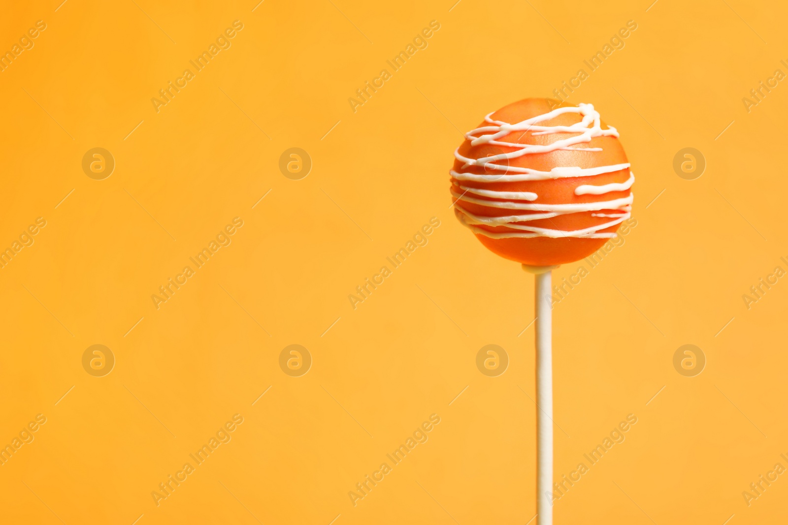 Photo of Bright delicious cake pop on color background. Space for text