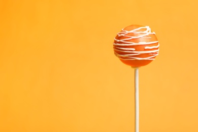 Photo of Bright delicious cake pop on color background. Space for text