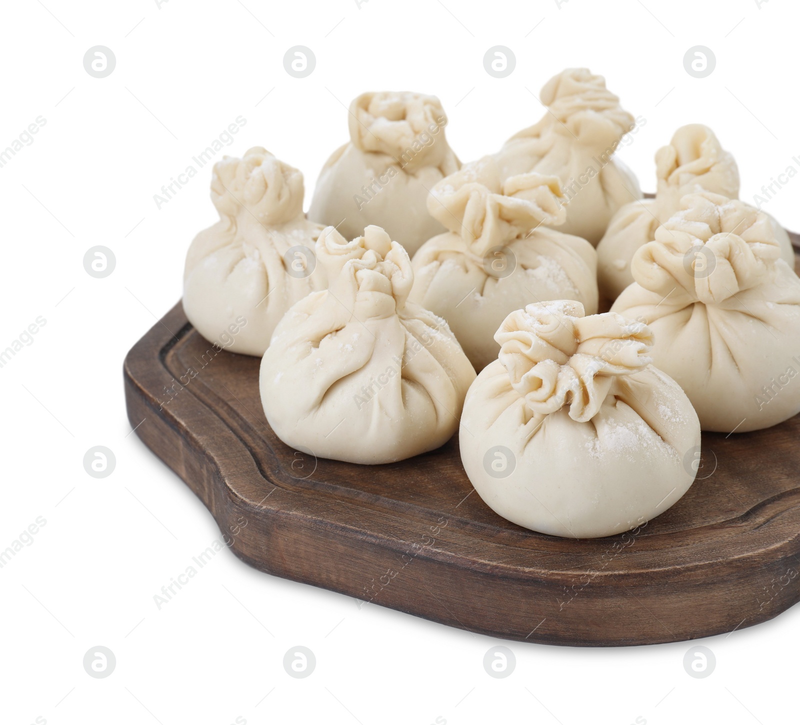 Photo of Wooden board with uncooked khinkali (dumplings) isolated on white. Georgian cuisine