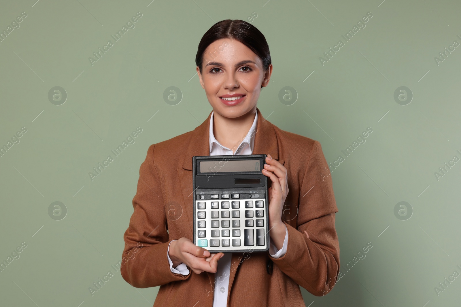 Photo of Smiling accountant with calculator on green background