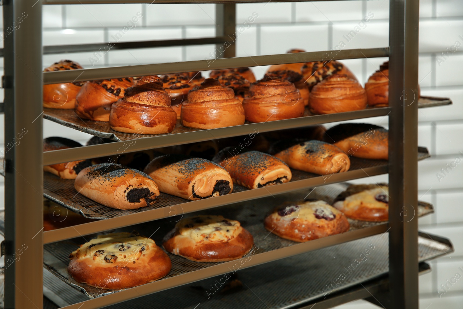 Photo of Rack with fresh pastries in bakery workshop