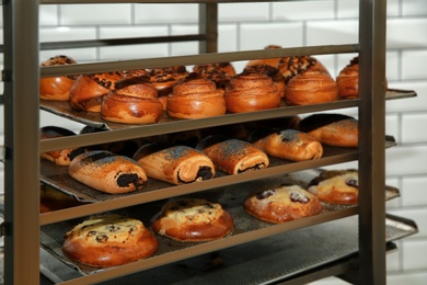 Photo of Rack with fresh pastries in bakery workshop