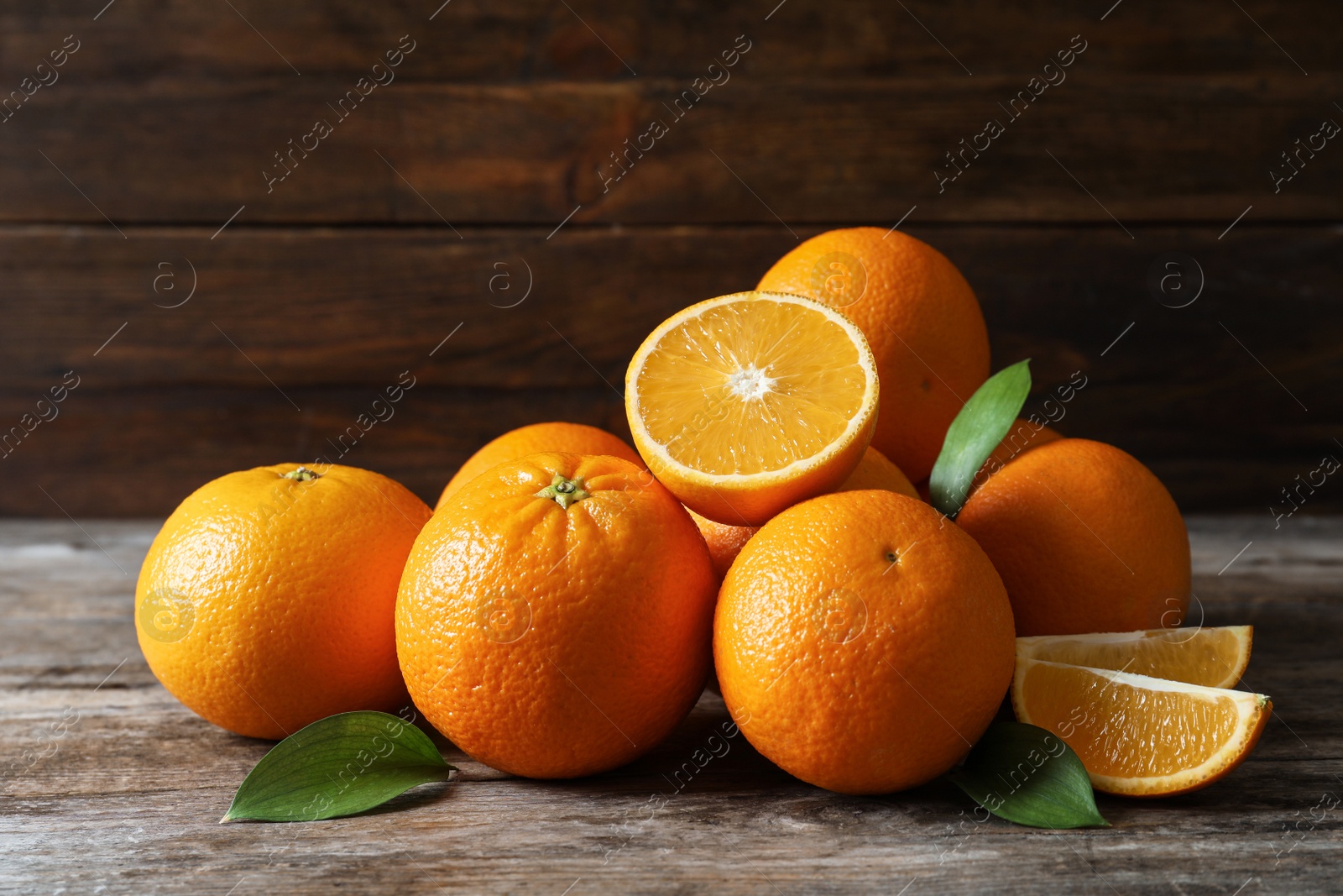 Photo of Fresh oranges with leaves on wooden table