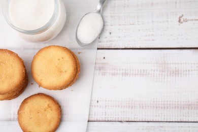 Photo of Tasty sweet sugar cookies on white wooden table, top view. Space for text