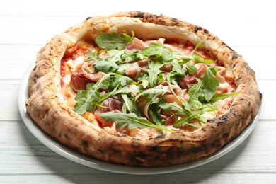 Photo of Tasty pizza with meat and arugula on white wooden table, closeup