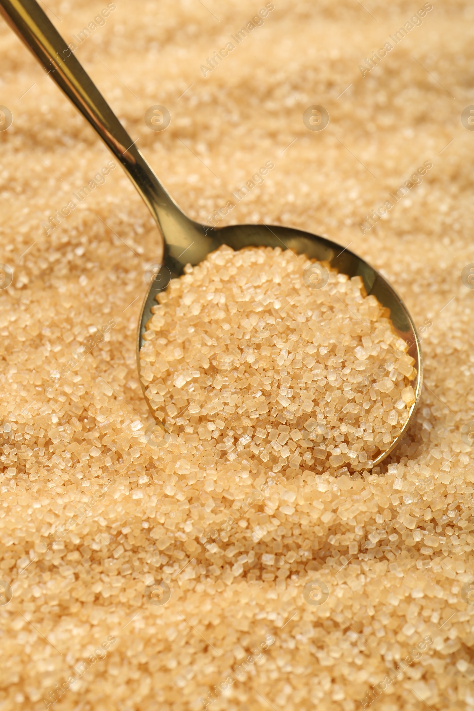 Photo of Spoon on granulated brown sugar, closeup view