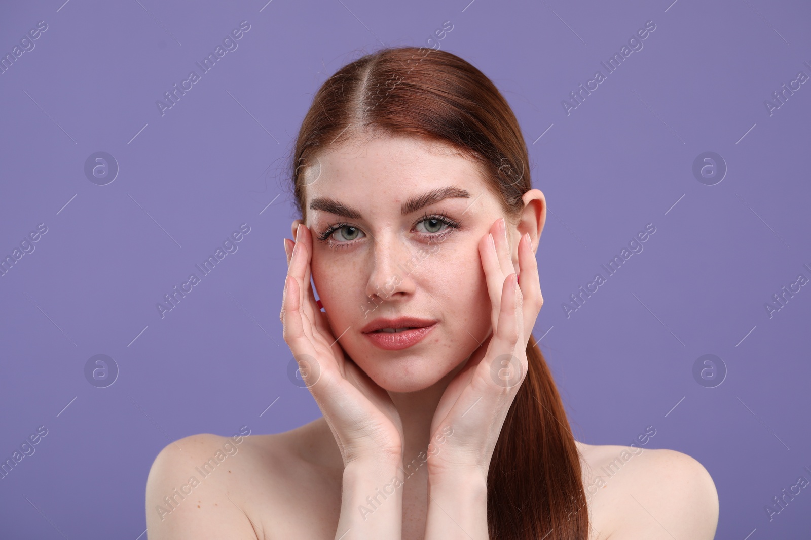 Photo of Portrait of beautiful woman with freckles on purple background