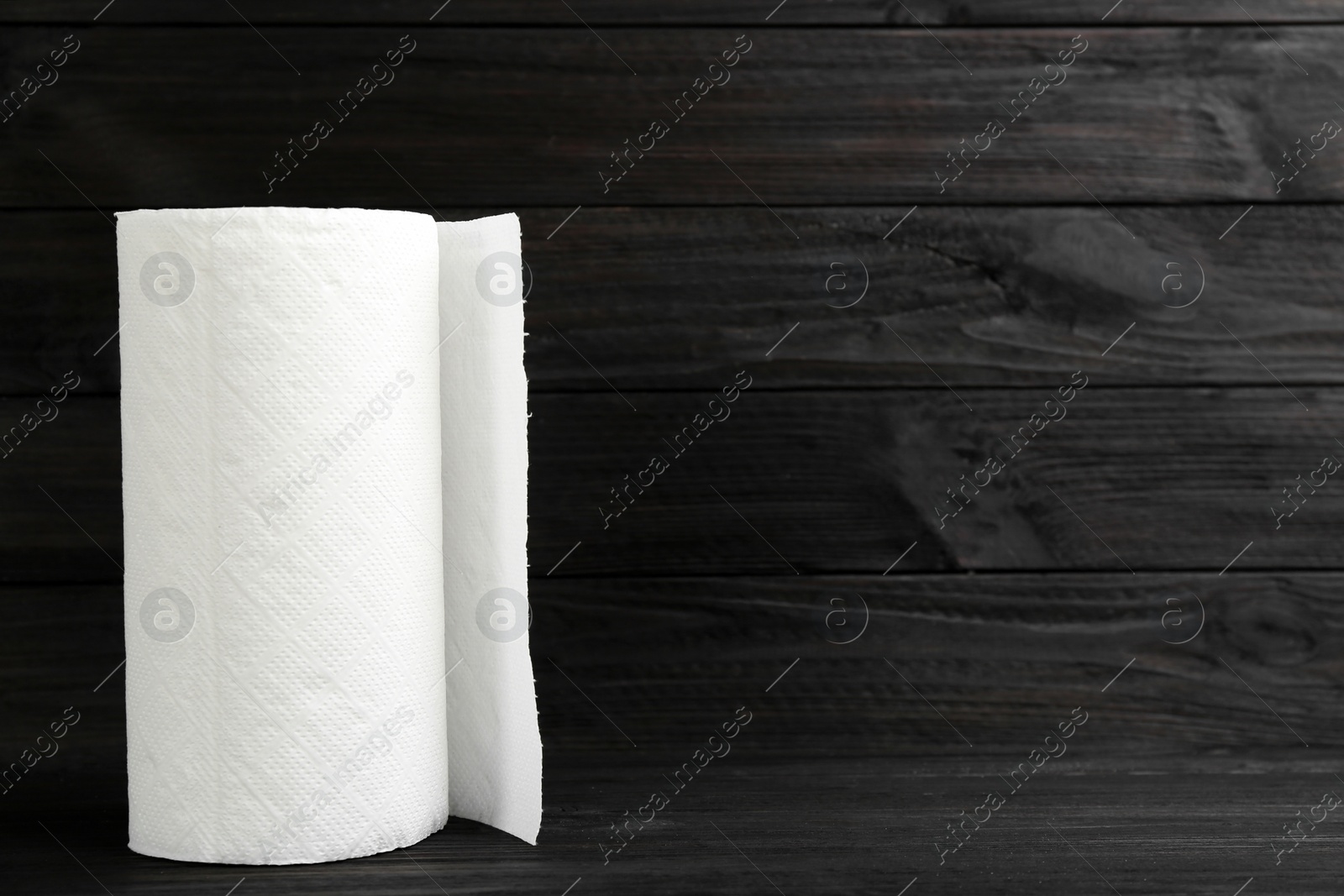 Photo of Roll of paper towels on wooden table, space for text